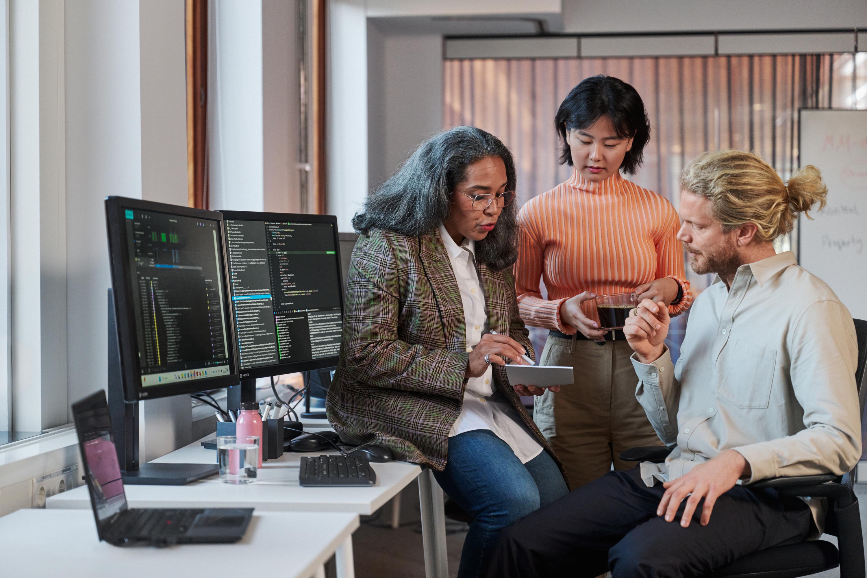 Spontant möte på en arbetsplats mellan tre kollegor